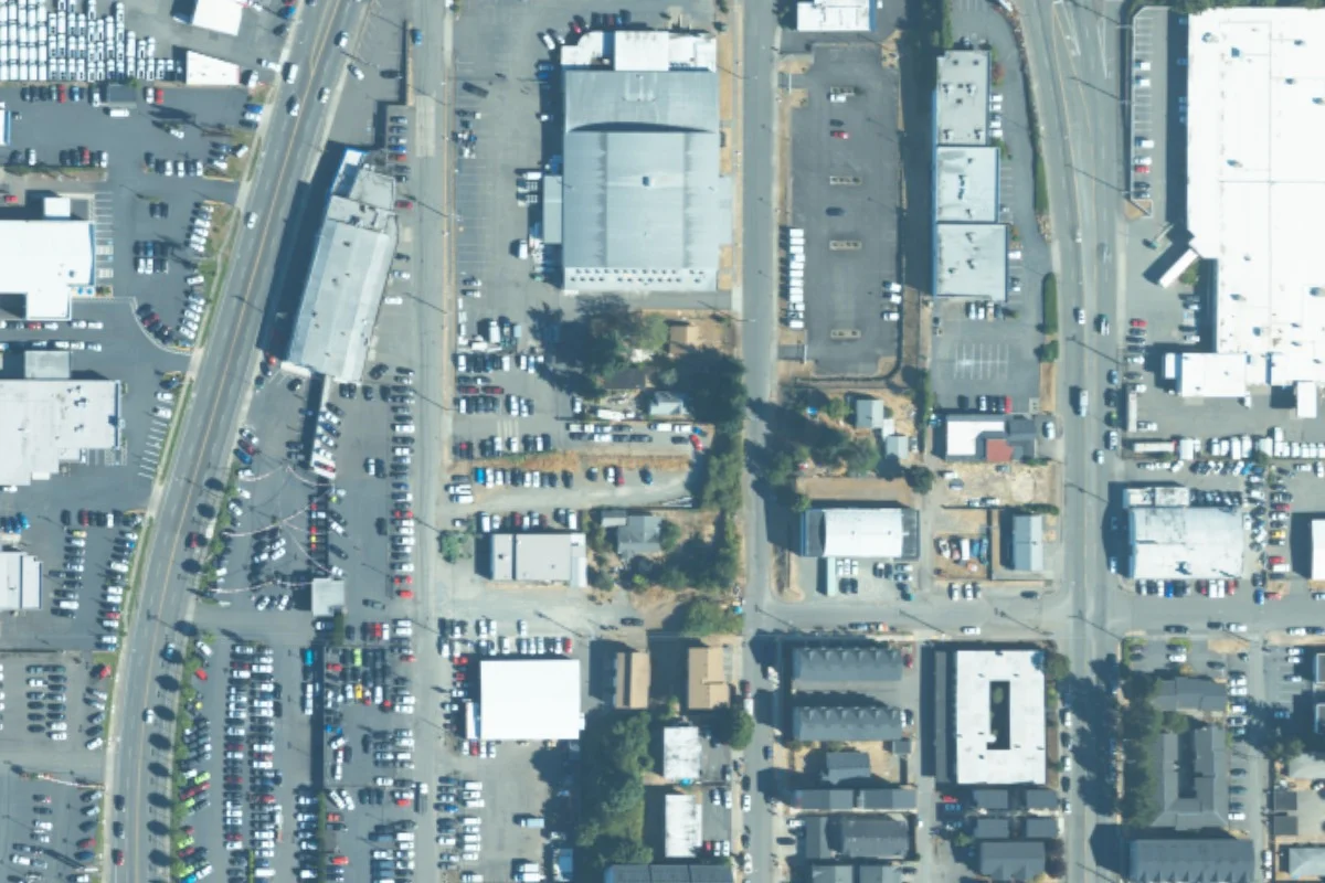 August 2023 aerial view around 3838 South Puget Sound Ave, with a green pin locating the vehicle lot