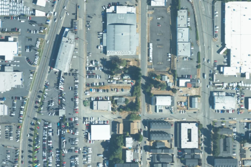 August 2023 aerial view around 3838 South Puget Sound Ave, with a green pin locating the vehicle lot