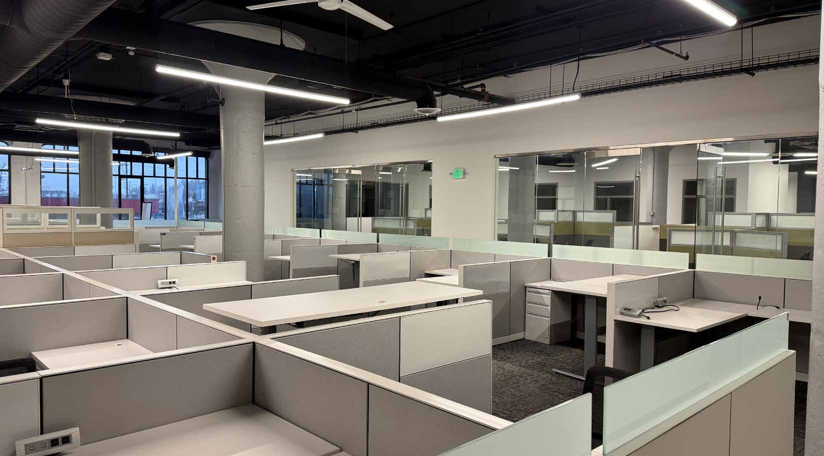 Open office interior with exposed structure and large windows